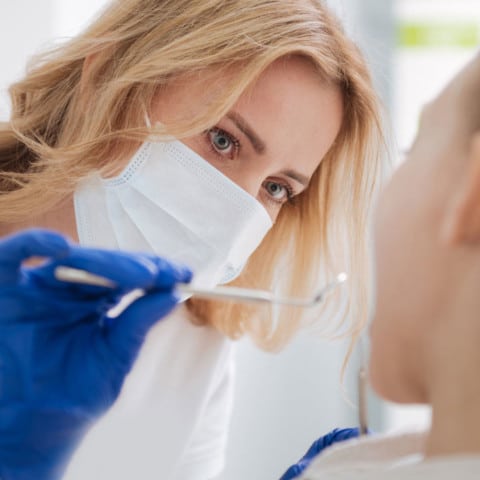 Female dentist giving oral exam