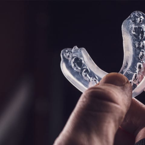 Person holding a sports mouth guard