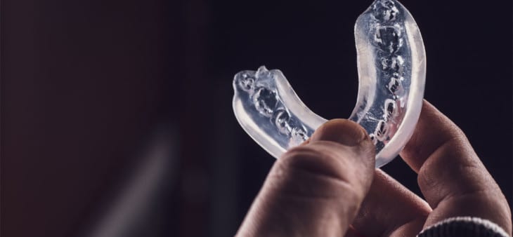 Person holding a sports mouth guard