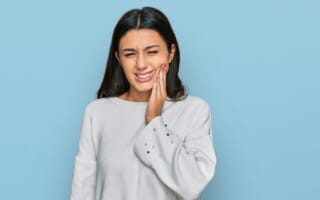 Young girl wearing casual clothes touching mouth with hand with painful expression because of toothache or dental illness on teeth