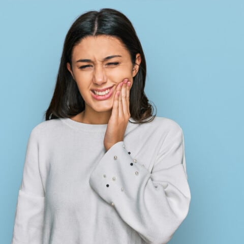 Young girl wearing casual clothes touching mouth with hand with painful expression because of toothache or dental illness on teeth