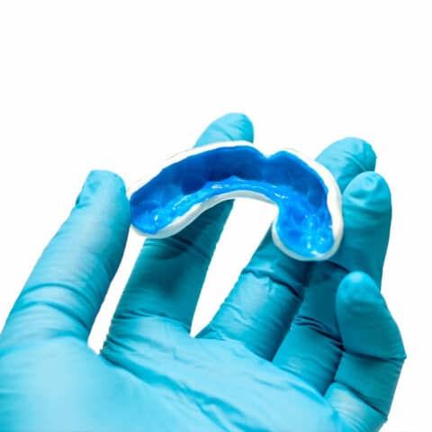 Dentist holding sports mouthguard in hand