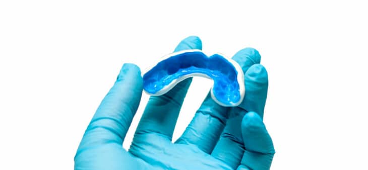 Dentist holding sports mouthguard in hand
