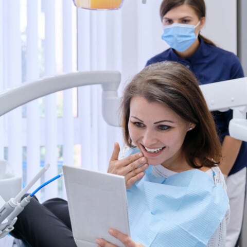 Woman at dentist looking at teeth in mirror