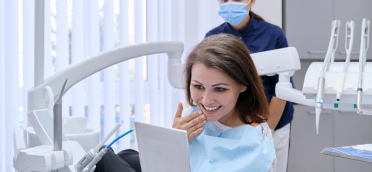 Woman at dentist looking at teeth in mirror
