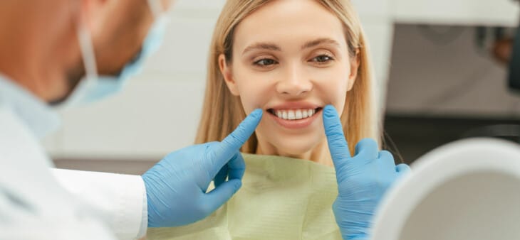 Female dental patient looking at teeth in dental chair
