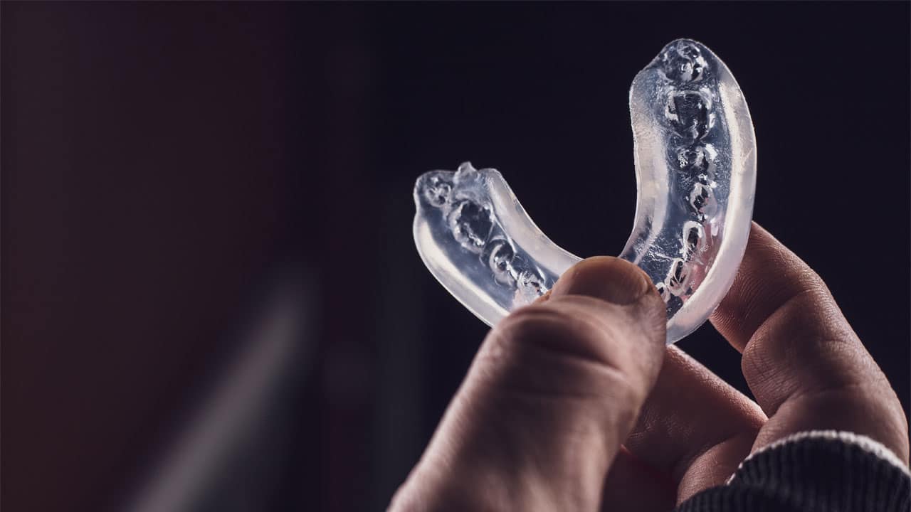 Person holding a sports mouth guard