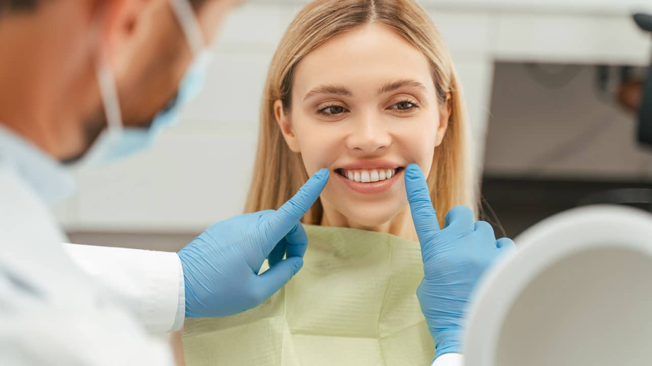 Female dental patient looking at teeth in dental chair