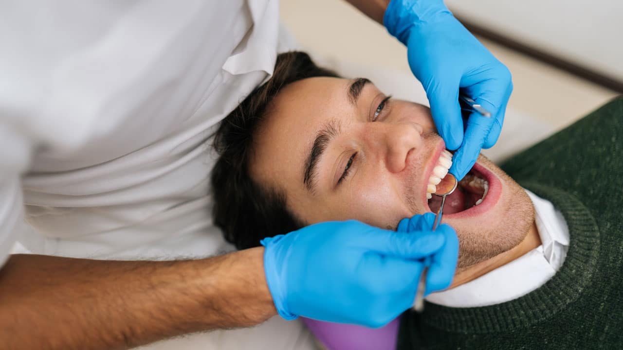 Young man having teeth checked by dentist
